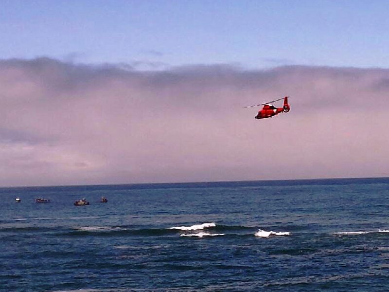 A Coast Guard helicopter drops the first wreath in the Pacific.